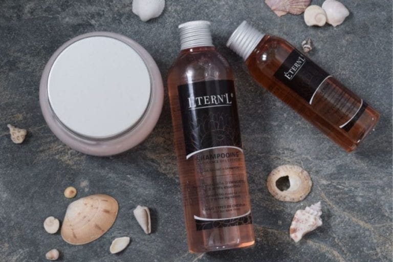 eternl hair care products on a slate floor with sea shells