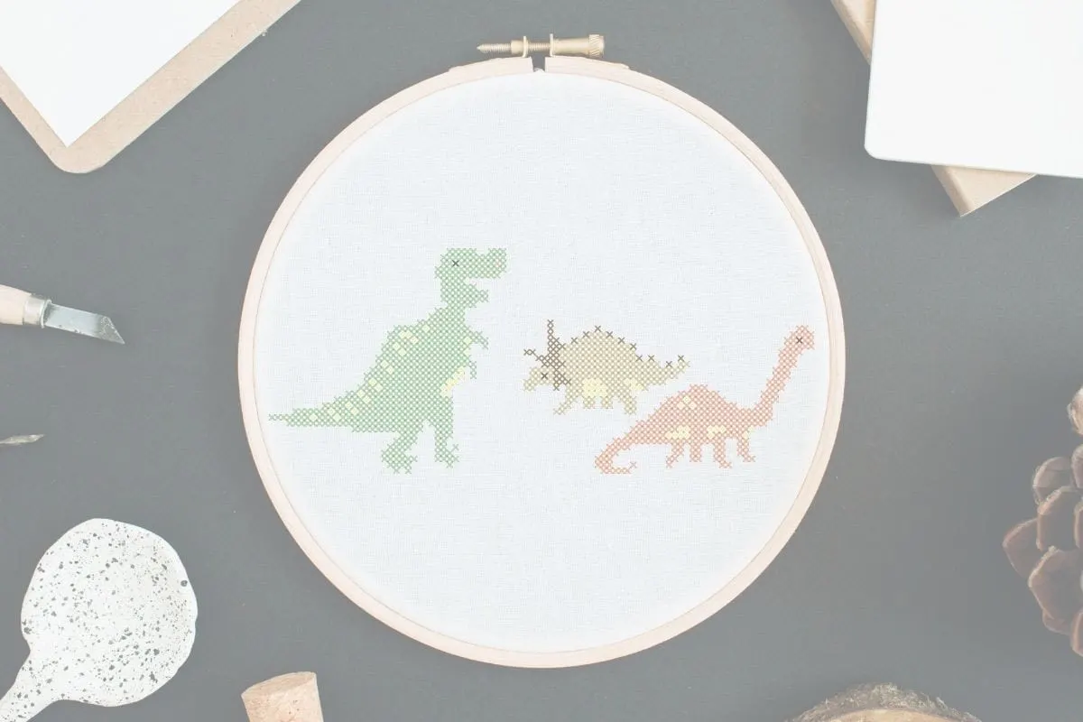 embroidered and framed 3 dinosaurs cross stitch