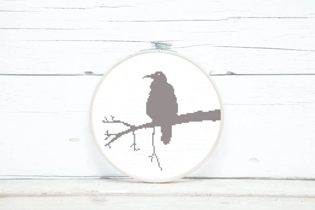 embroidered and framed in a hoop raven cross stitch