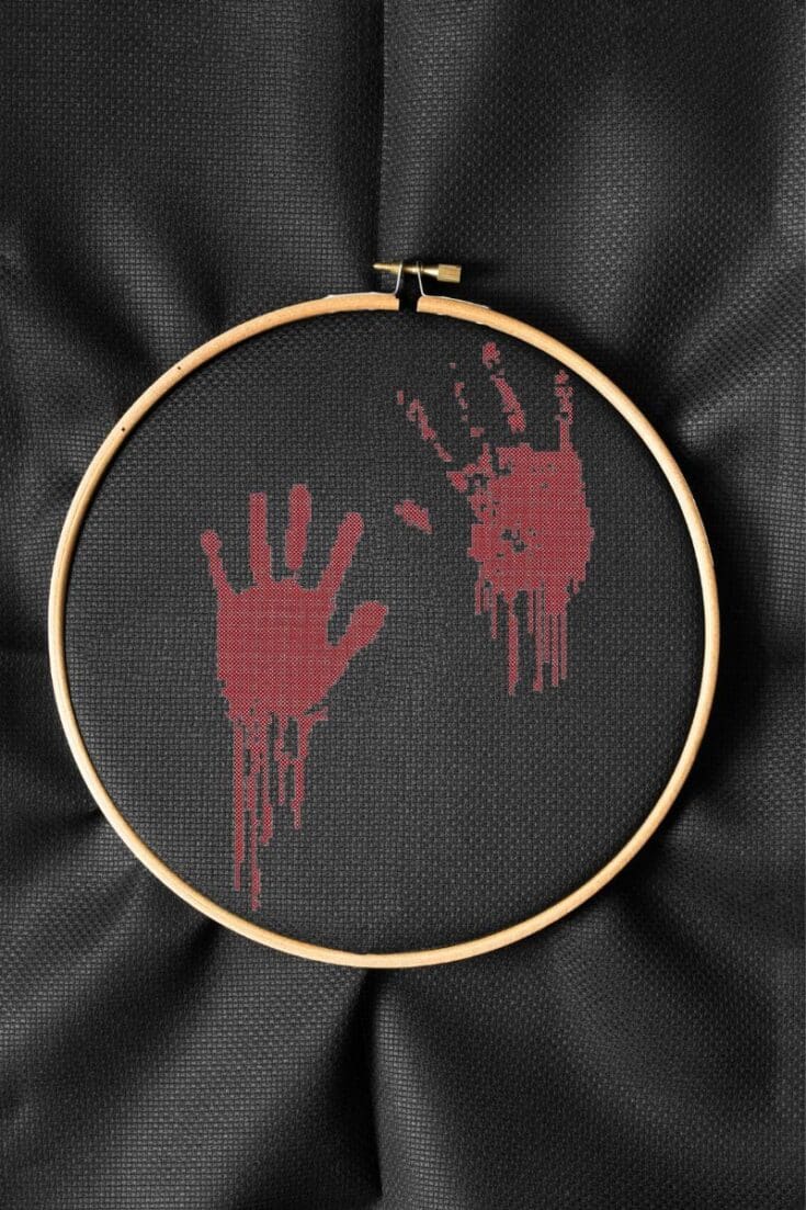 embroidered and framed in a hoop bloody handprints cross stitch