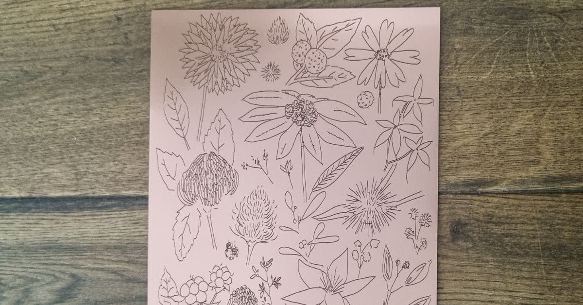 Images shows Australian flora and flowers laser engraved onto copper sign material lay on oak floorboards