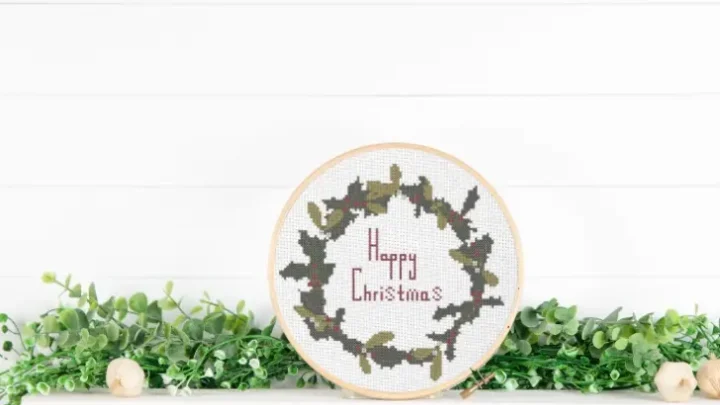 embroidered and framed holly wreath cross stitch