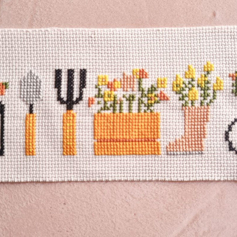 close up of embroidered cross stitch garden motifs