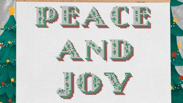 Image shows an embroidered peace and joy cross stitch on a fabric banner, against a painted mural of Christmas trees