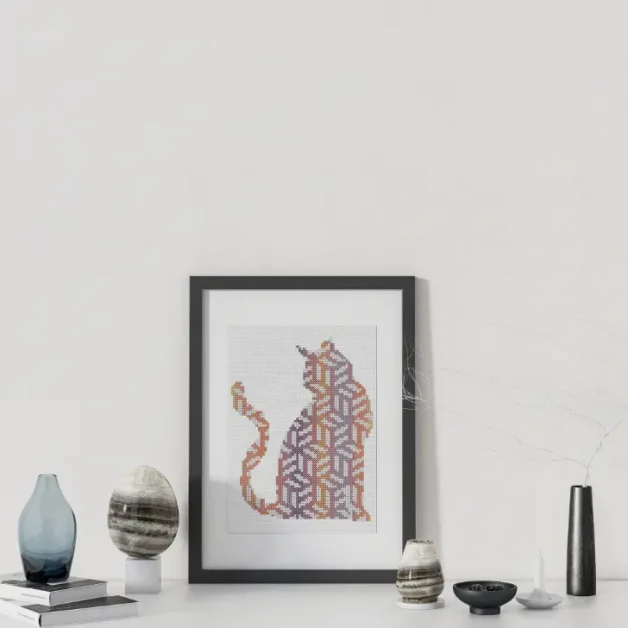 geometric cubist cat cross stitch pattern stitched and framed in a black frame