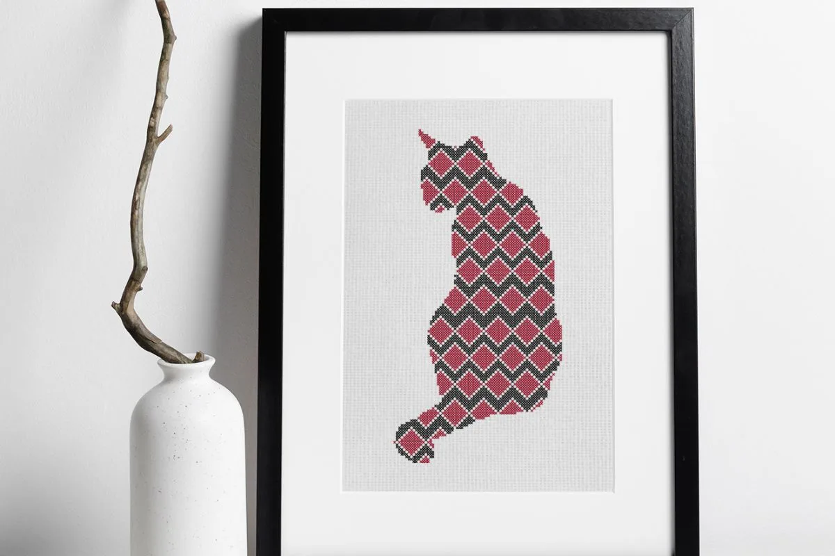 embroidered and framed red and black cat cross stitch