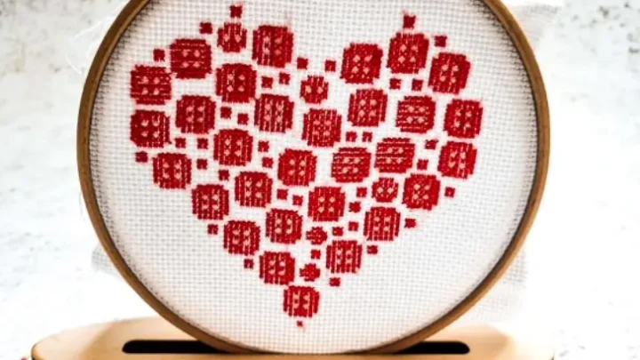 embroidered and held in a hoop button heart cross stitch