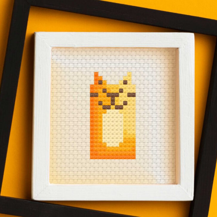 embroidered and framed orange cat cross stitch