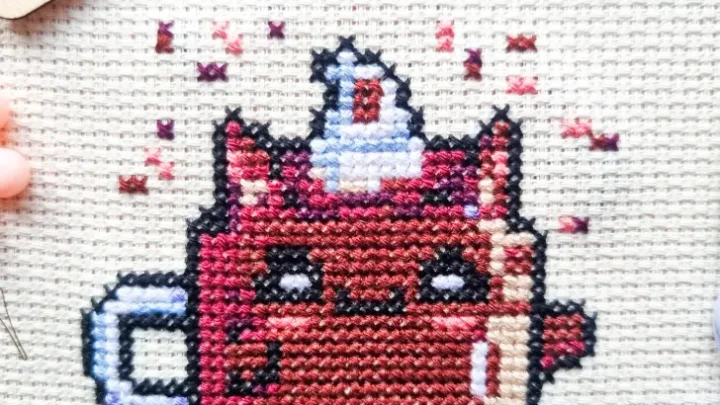 embroidered kawaii cat chocolate cross stitch pattern with stork scissors next to it