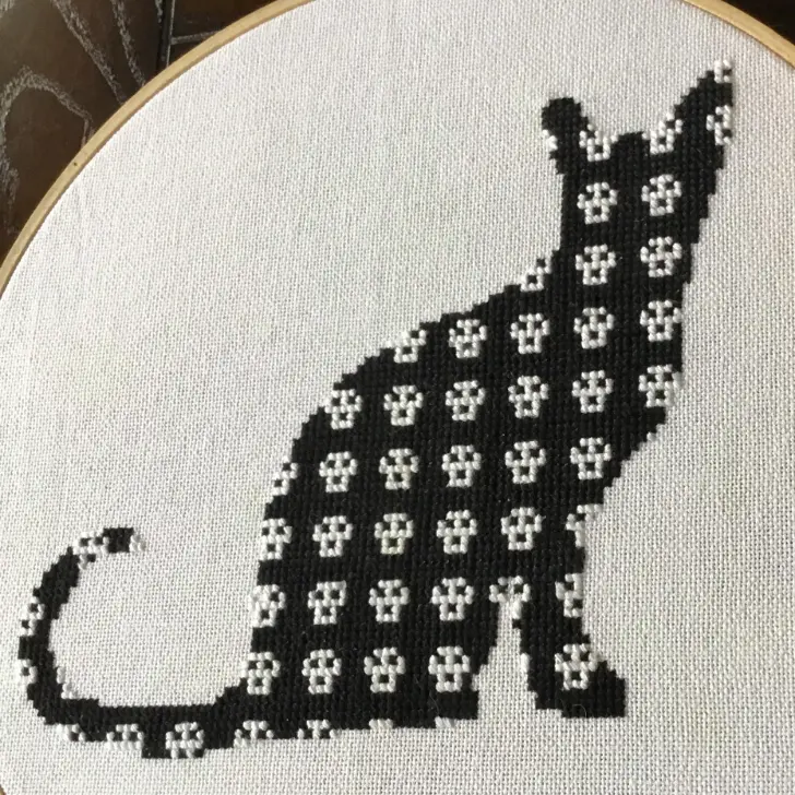 embroidered and framed skull cat cross stitch