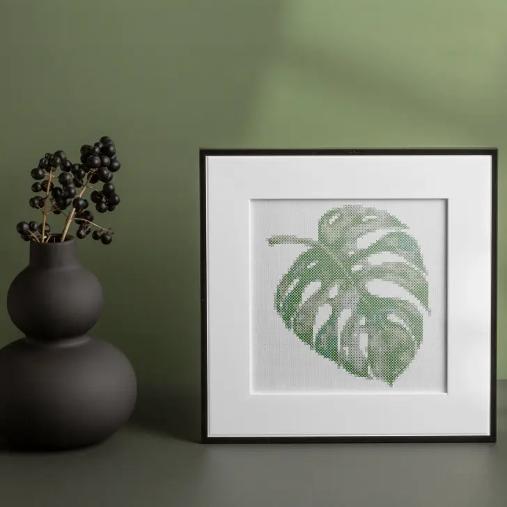 embroidered and framed monstera leaf cross stitch