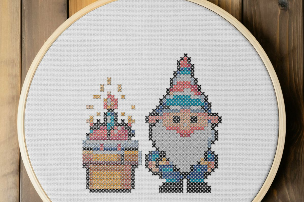 embroidered and framed in a hoop birthday cake gnome cross stitch