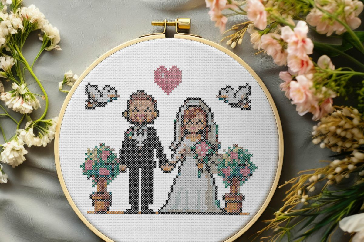 embroidered and framed in a hoop with flowers surrounding, wedding day cross stitch